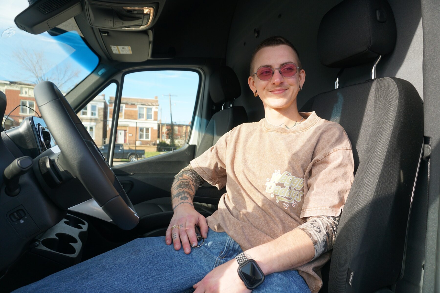 Murphy smiling in the driver’s seat of the Waggy Daddys grooming van